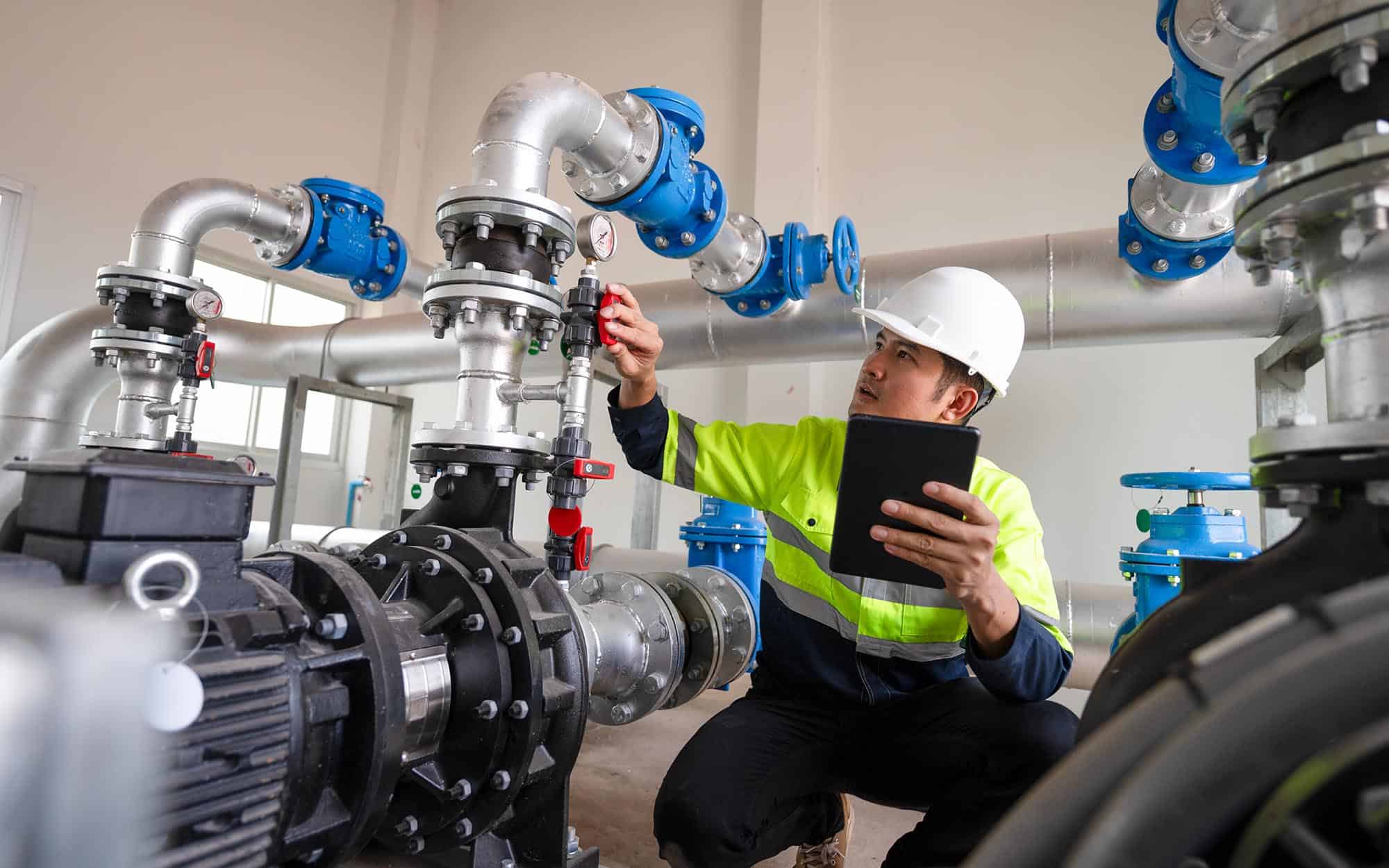 Technician adjusting chilled water piping on a Dubai project