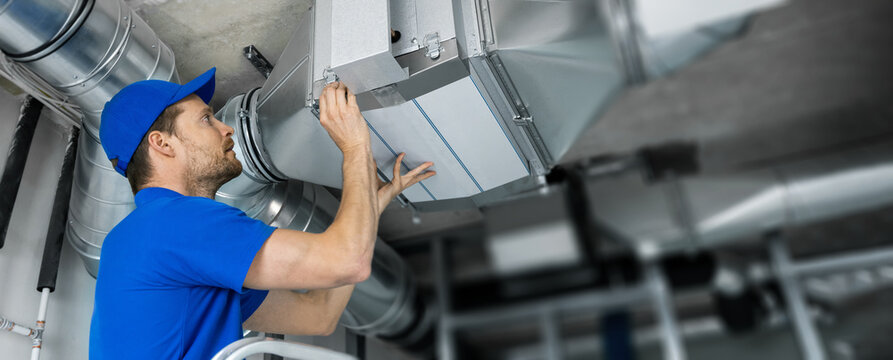 Technician installing HVAC ductwork